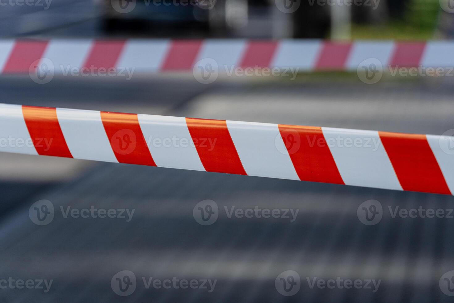 A striking warning barrier stretches across a city street, signaling danger and preventing unauthorized entry during daylight hours photo