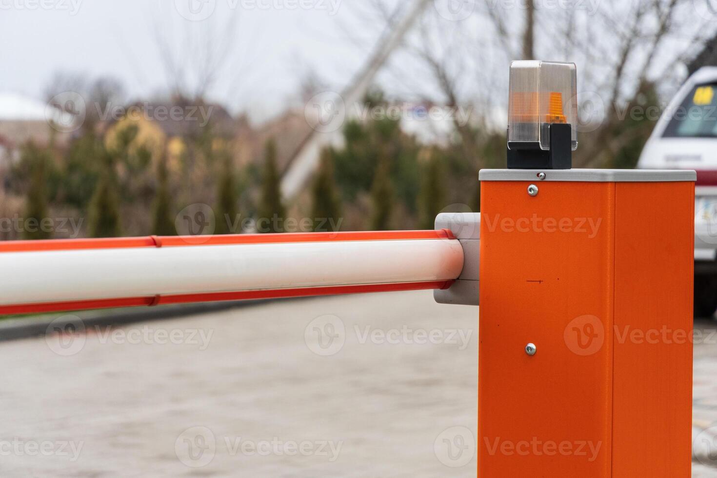 An automatic gate stands closed at a parking lot entrance, designed for security and controlled access, promoting safe vehicle entry photo