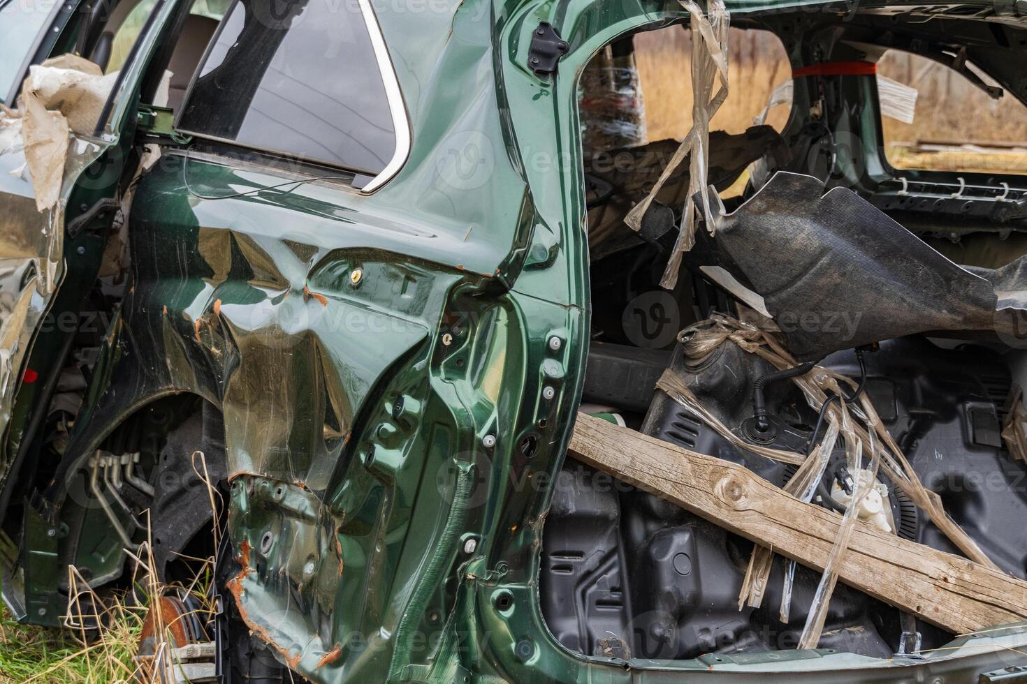 A severely damaged vehicle lies in a field after a crash, illustrating the tragic results of road accidents and the need for safety photo