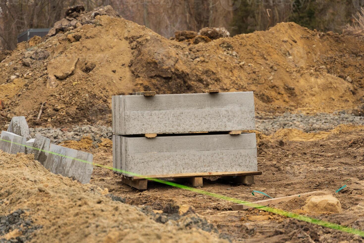 Gravel and concrete blocks rest at a construction site, highlighting ongoing repairs in an industrial area along a busy city road photo