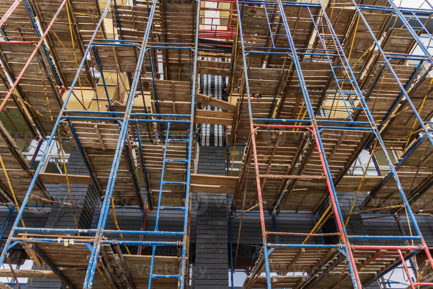 Workers utilize scaffolding to enhance safety and access during the construction of a multi-story building in a busy area photo