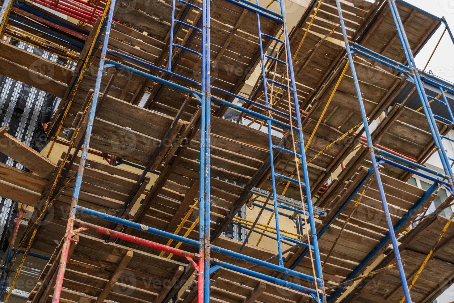 Workers assemble extensive scaffolding for the construction of a new building, highlighting industrial progress in urban development photo