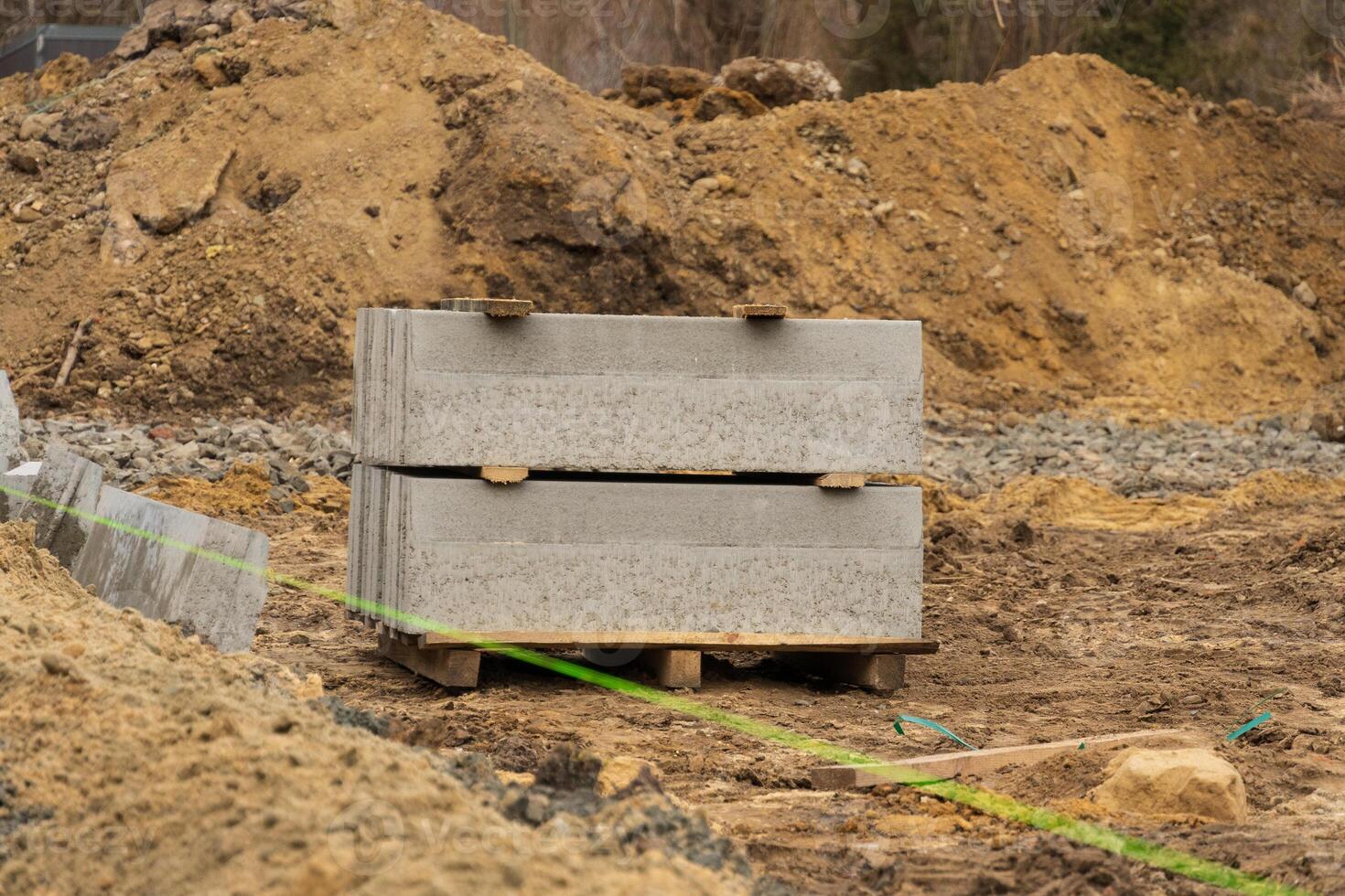 Construction materials sit on a gravel surface by a city street, indicating ongoing repairs and efforts to improve urban infrastructure photo
