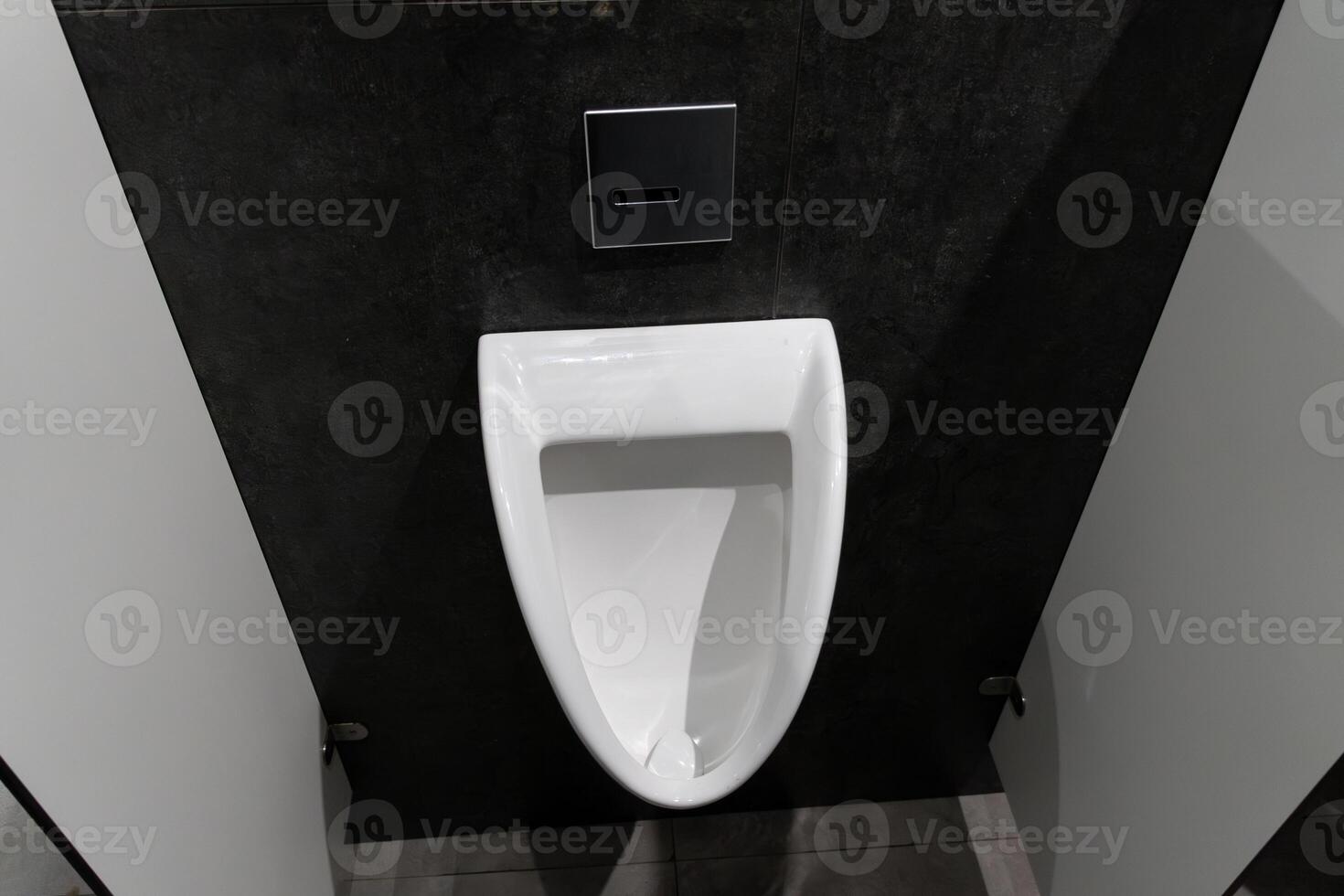 Minimalist urinal situated in a clean, modern restroom, highlighting hygiene and comfort in a public setting for male users photo