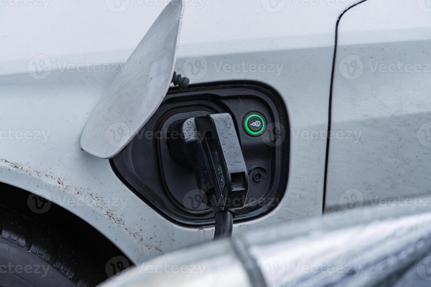 An electric vehicle is connected to a charging station, highlighting advancements in renewable energy and efficient transportation solutions photo