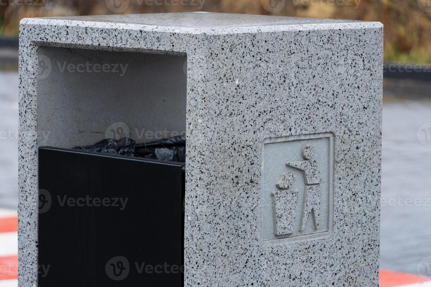 Urban area features a concrete garbage container designed for efficient waste disposal and environmental conservation practices photo