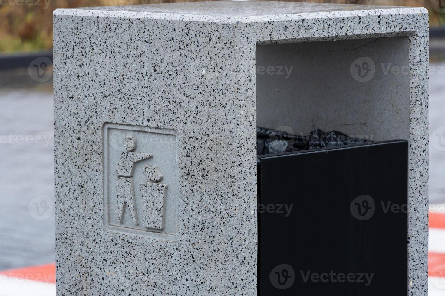 Solid gray container for rubbish and recycling stands empty, encouraging proper waste disposal in an urban environment photo