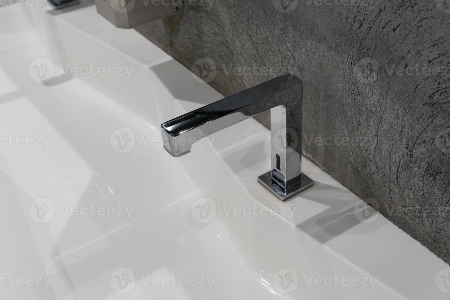 This contemporary restroom showcases a clean and spacious design highlighted by a sleek sink and frosted glass accents, perfect for hygiene photo