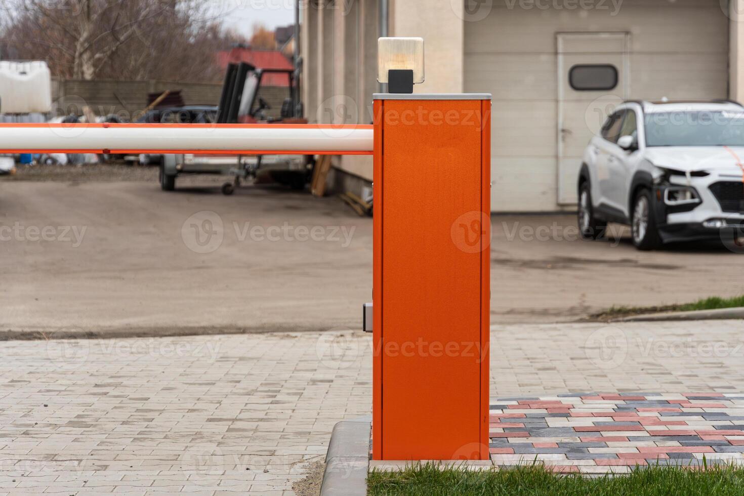 An automatic barrier gate stands closed at a parking lot entrance, ensuring secure access for vehicles at this commercial location photo