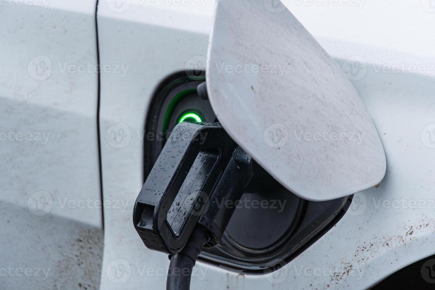 An electric vehicle connects to a charging station, highlighting advancements in transportation and renewable energy solutions for the future photo