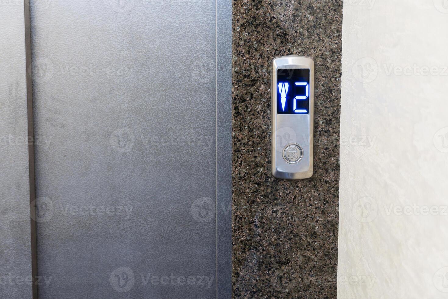 Control panel in a contemporary elevator displays the number two, indicating the second floor in a multi-story apartment setting photo