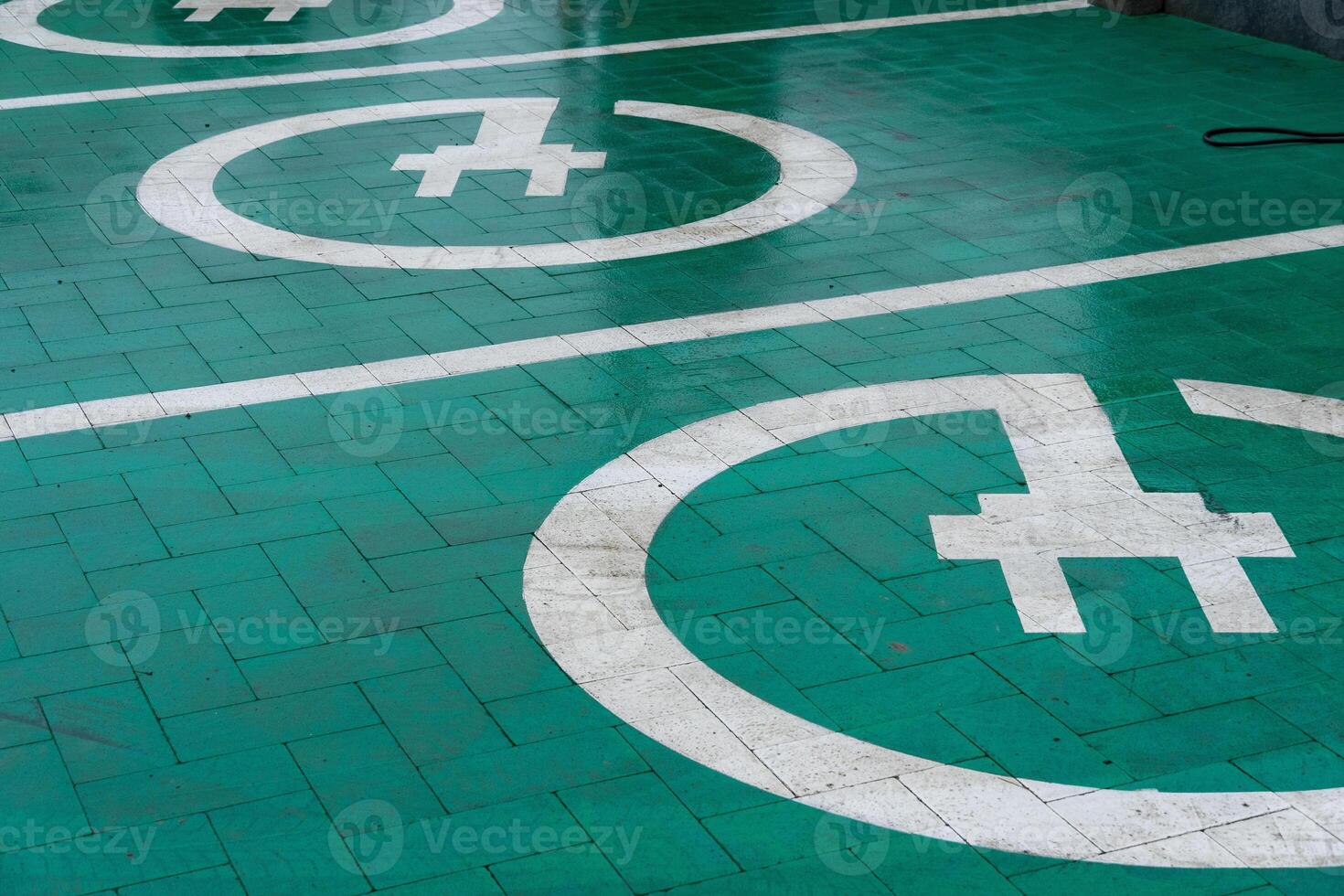 Chargers are marked on the ground, indicating spots for electric vehicles to connect for energy replenishment in a contemporary setting photo
