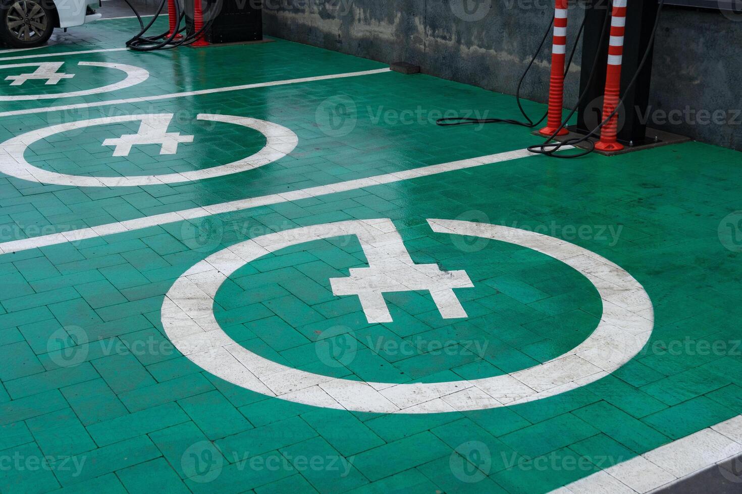 Charging points for electric cars marked on vibrant green pavement, showcasing renewable energy solutions for modern vehicles photo