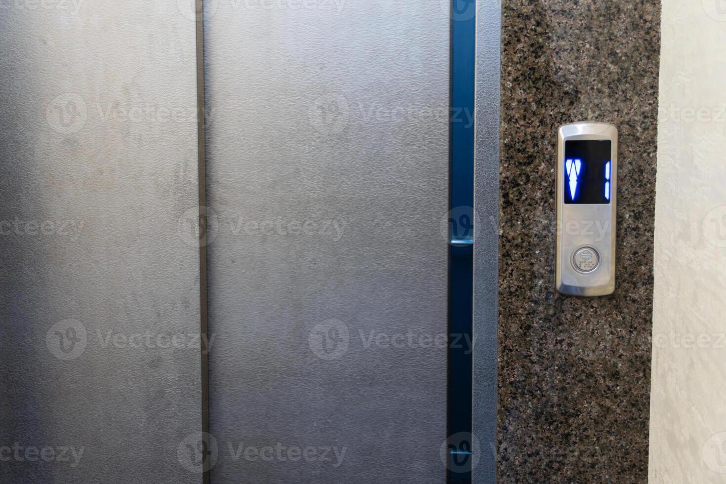 Steel elevator control panel showcases illuminated buttons indicating floor numbers for easy navigation within a building photo