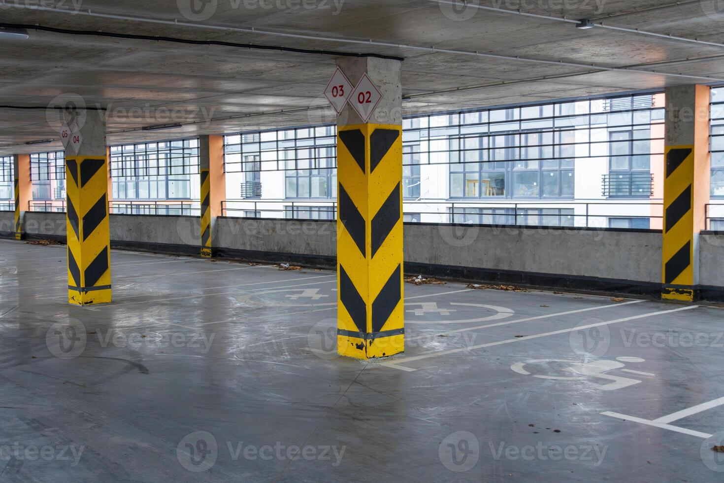 Spacious parking garage with designated spots and safety markers, providing secure vehicle storage in a contemporary urban environment photo