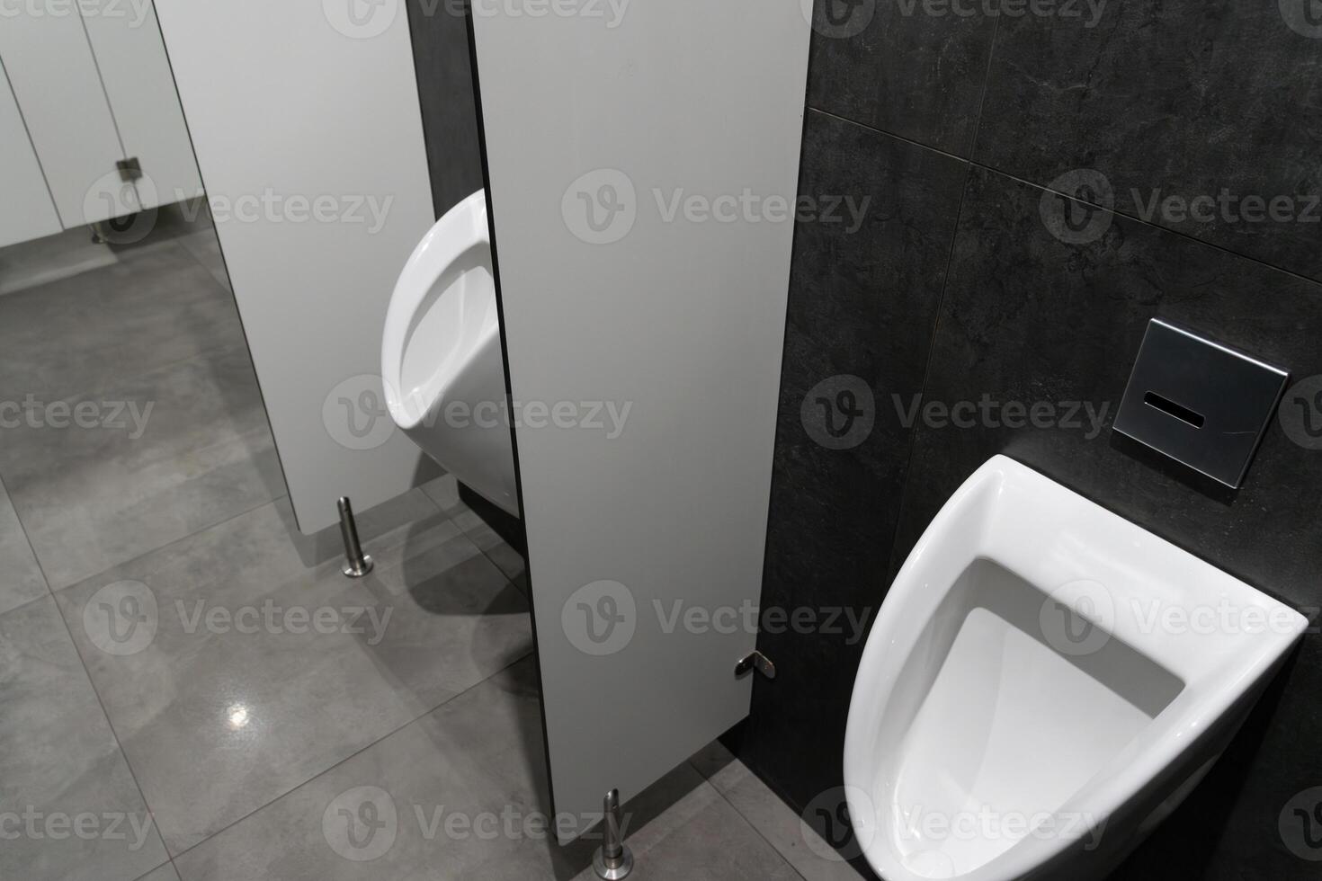 This restroom features a contemporary design with a focus on cleanliness, showcasing a stylish urinal and hygiene-friendly aesthetics photo