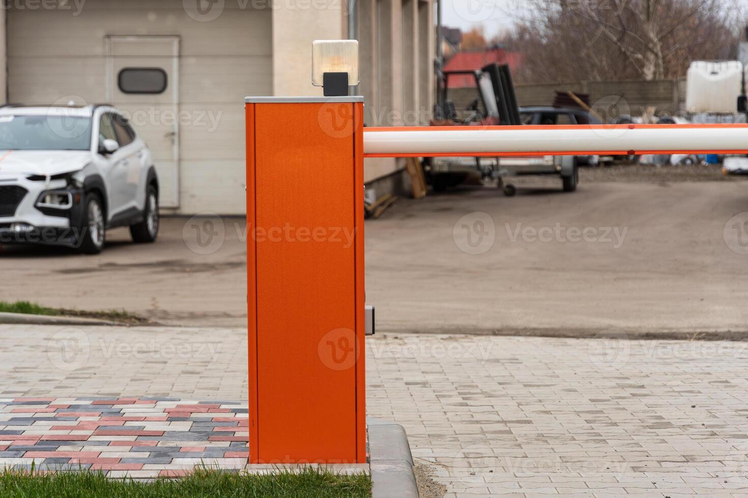 An automatic barrier gate stands closed at the entrance to a parking lot, ensuring secure access control and safety for vehicles photo