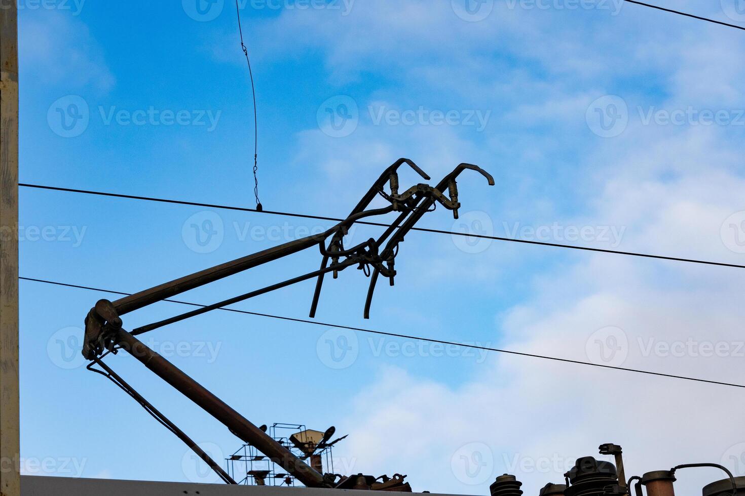 Overhead lines for electric trains stretch against a bright blue sky, showing modern transportation infrastructure at a railway station photo