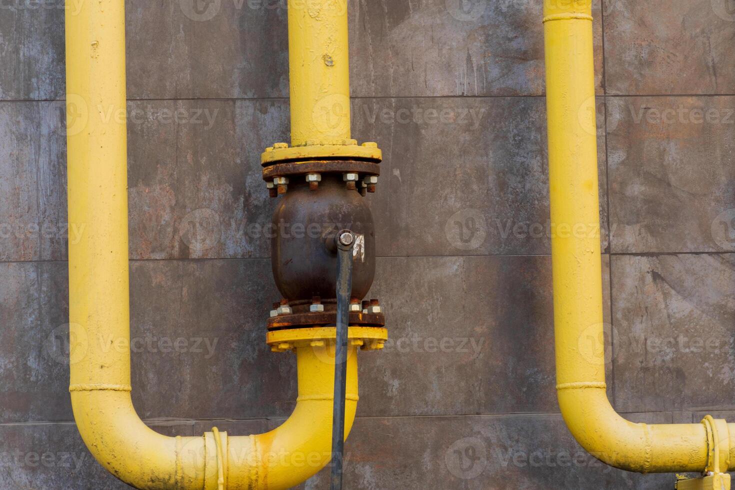 Yellow metal pipes and valves showcase a gas pipeline connection within an industrial infrastructure, highlighting energy transportation technology photo