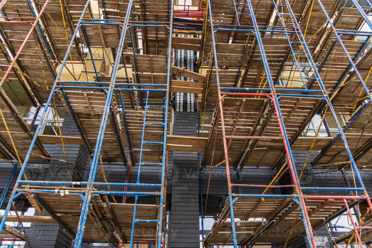 Workers navigate a complex scaffolding structure at a construction site, emphasizing safety and efficient development practices photo