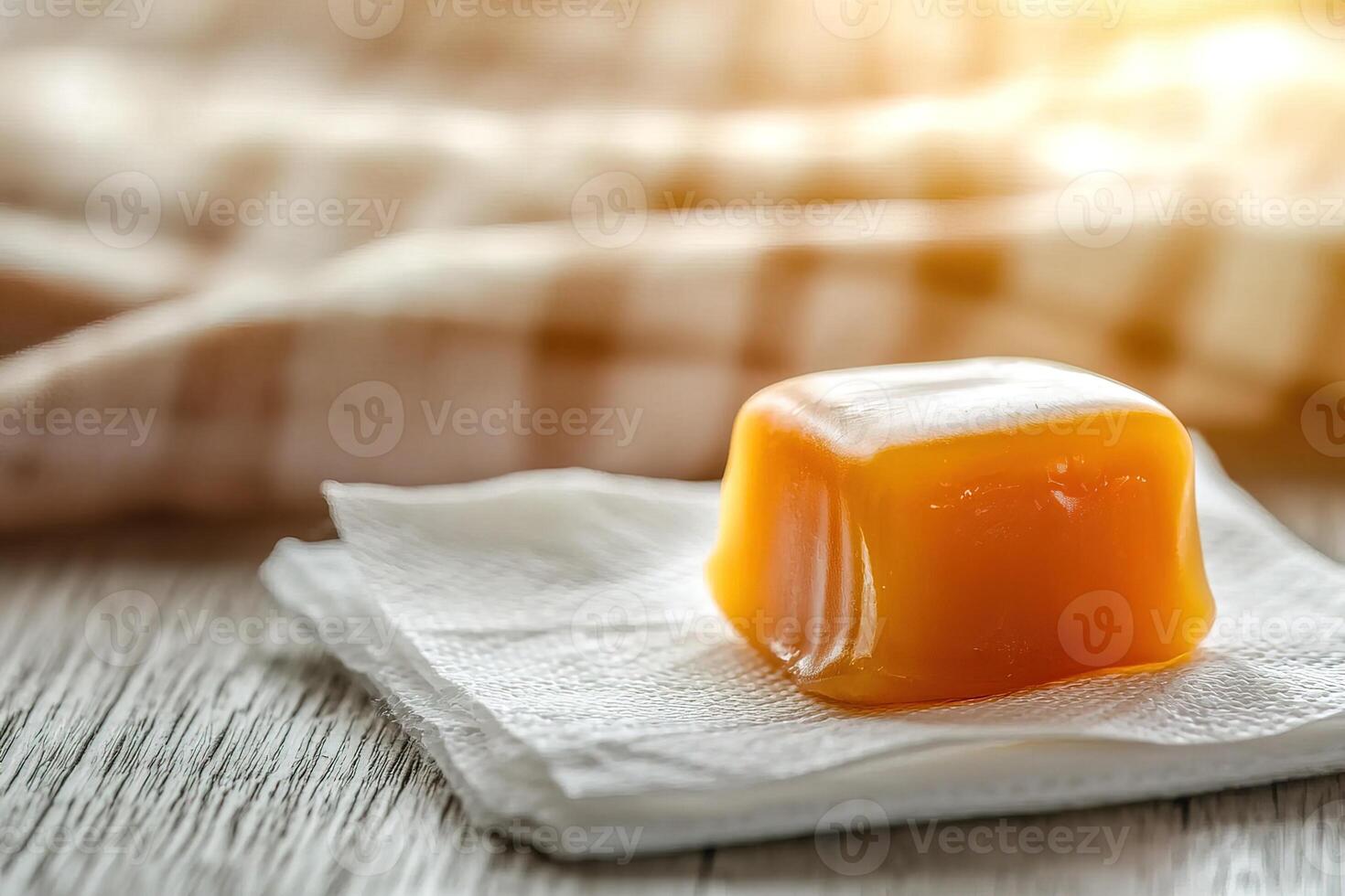 Artistic food photography of single caramel treat on white napkin, framed by soft lighting and minimalist styling to evoke warmth and indulgence. culinary social media, product catalogs, brand visuals photo