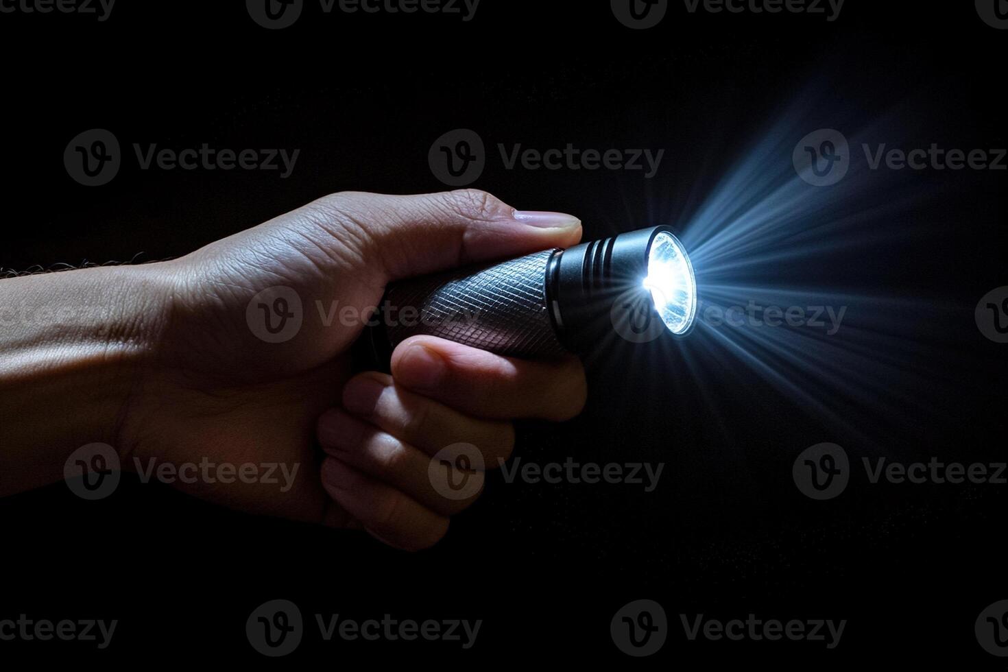 close-up of a hand gripping a glowing flashlight in a dark setting, symbolizing themes of exploration, mystery and the search for truth photo