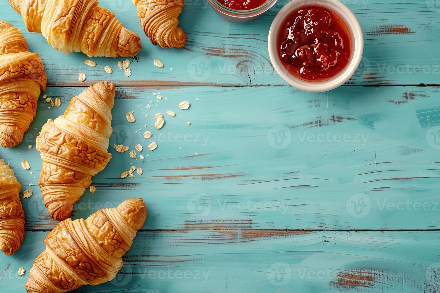 Top view mockup of freshly baked croissants with glass jar of jam on rustic blue wooden background, perfect for breakfast or brunch concepts photo