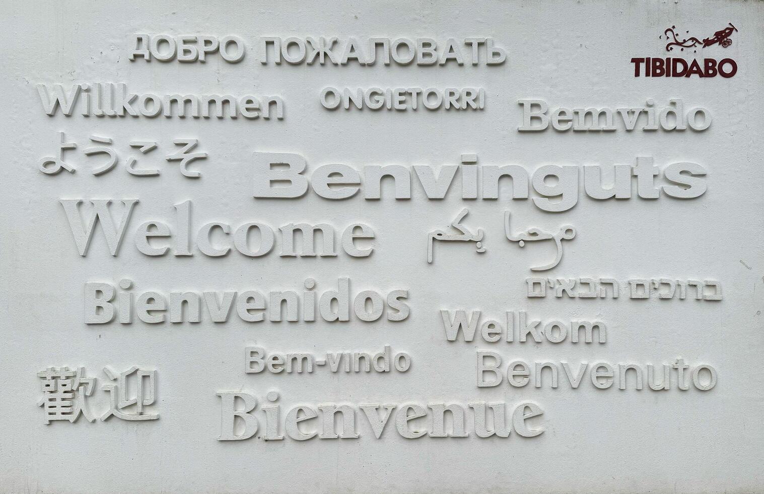 Barcelona, Spain - March 26, 2025. Tibidabo. Multilingual welcome sign featuring various languages at Tibidabo amusement park in Barcelona, Spain with artistic design photo