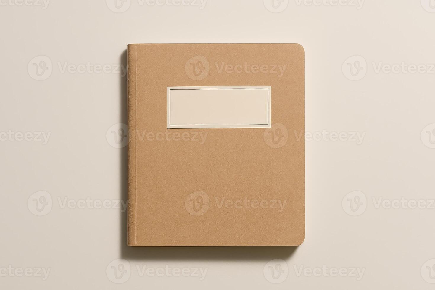 Closed brown kraft notebook with blank label on beige background. Minimal stationery mockup for branding or identity design photo