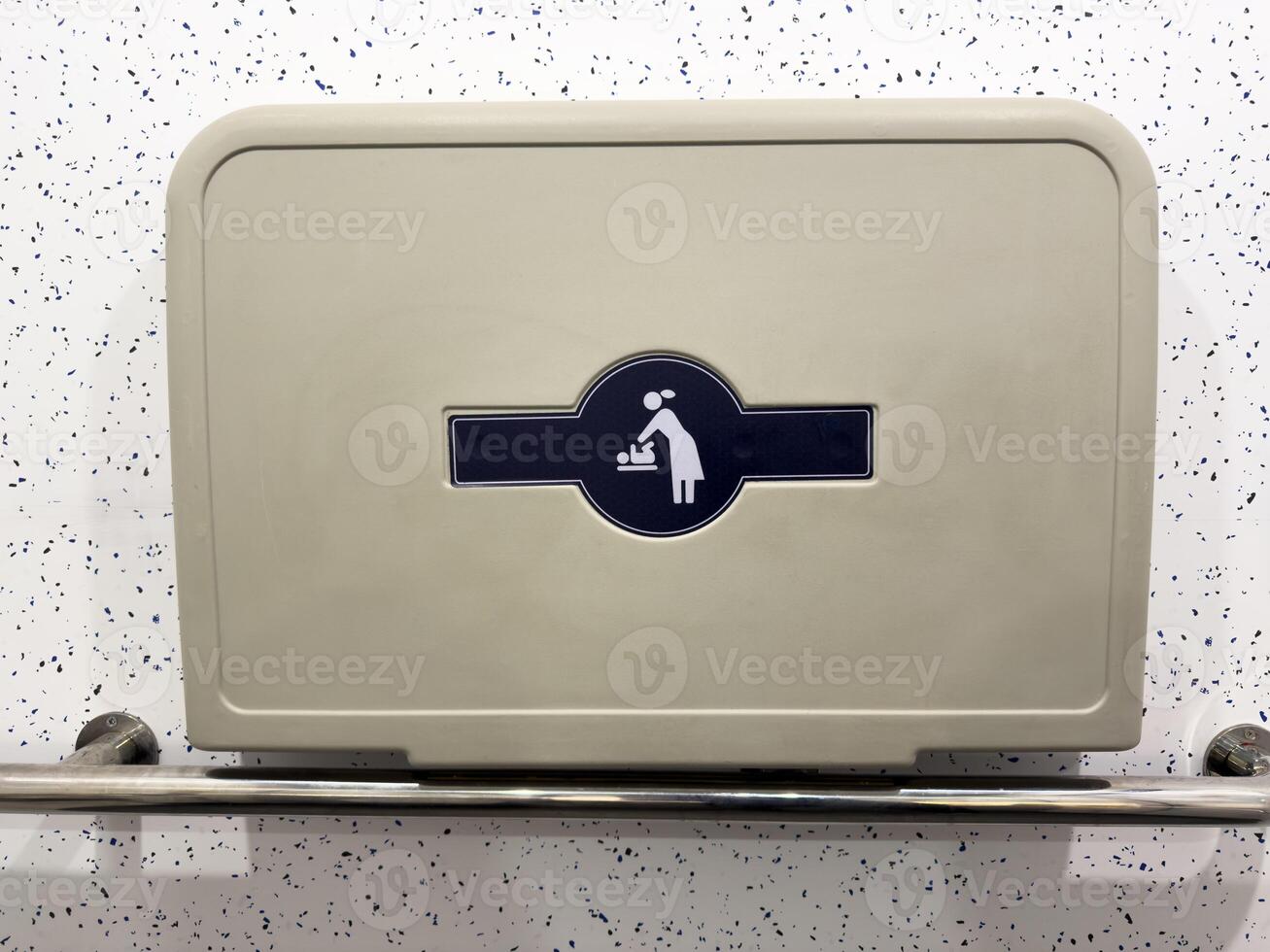 Baby changing symbol on wall mounted foldable table in public restroom. Clear icon for parents, providing visual guidance and enhancing accessibility in modern public infrastructure photo