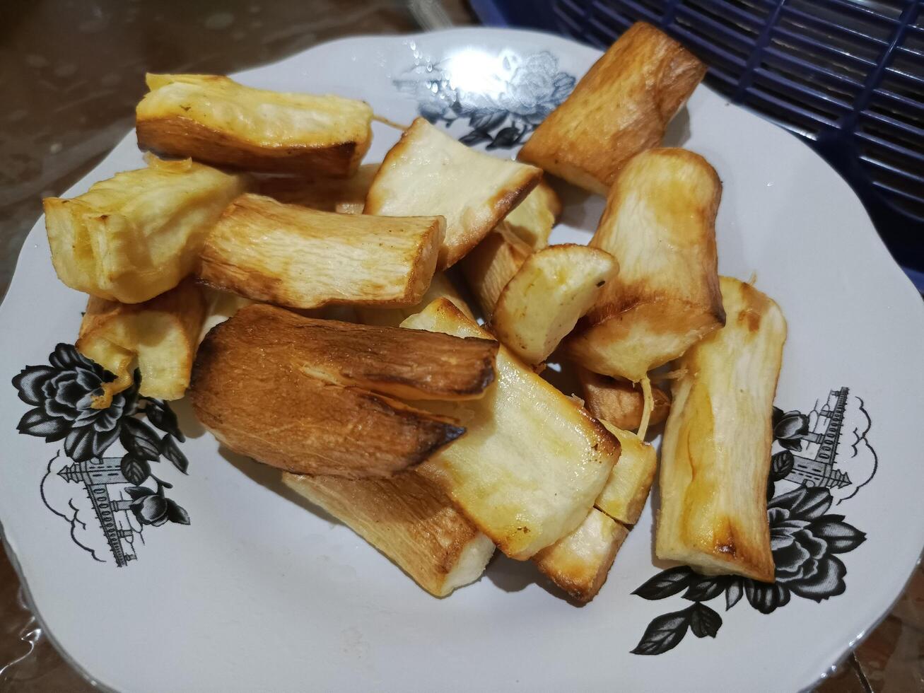 Golden fried sweet potato slices on a patterned plate, a simple and delicious snack photo