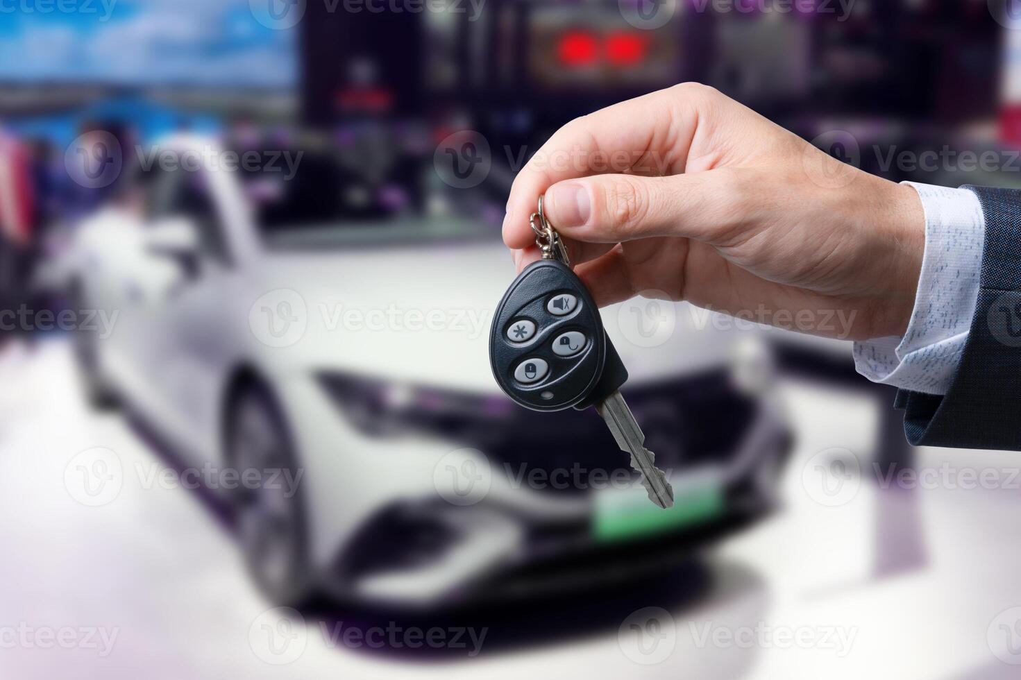 Close-up of dealer handing keys to new owners at a car show Automotive business Car sales Agreement Concept Men car salesman handing over new car keys. photo