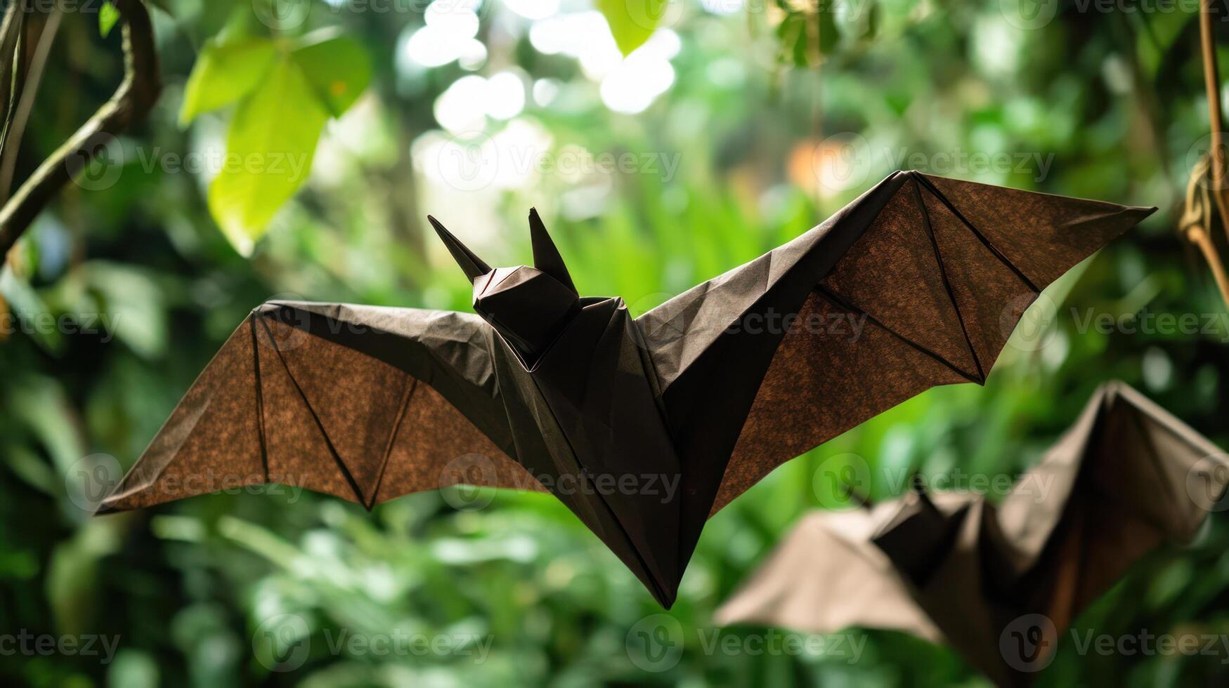 Origami paper bats fly in a forest with vibrant green foliage photo