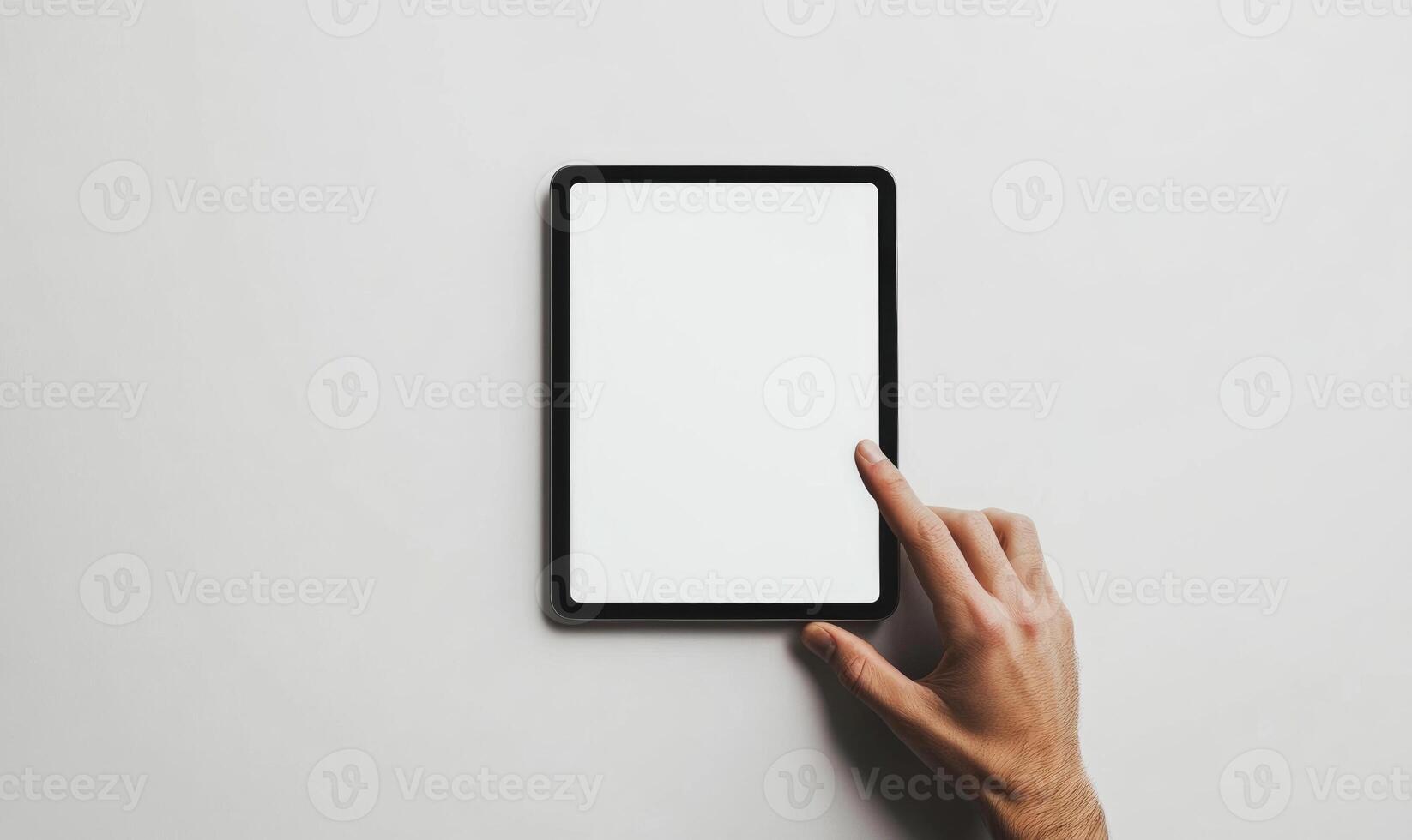 A person is pointing at a tablet with a white screen photo