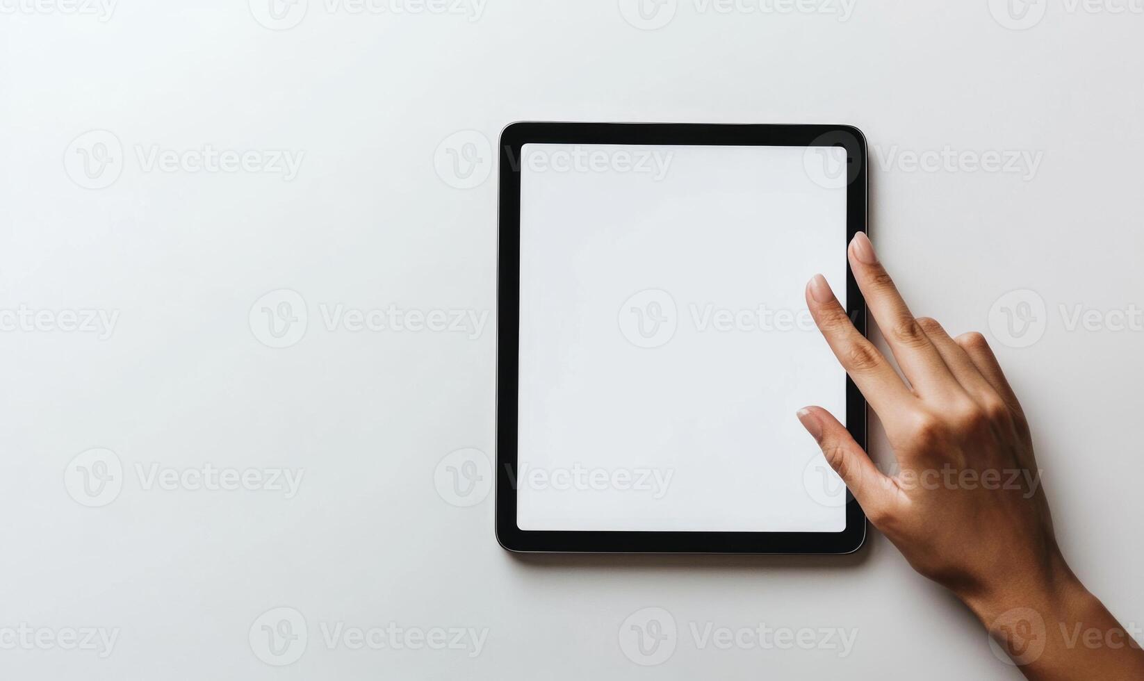 A hand is pointing at a tablet with a white screen photo