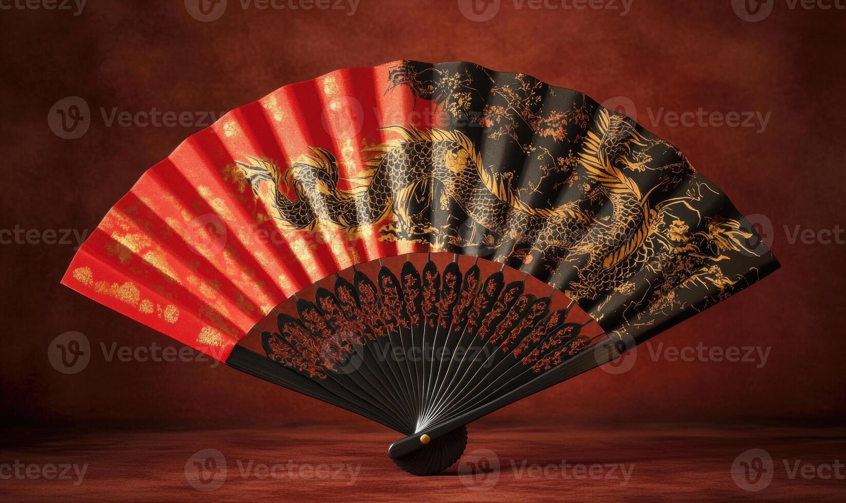A red and black dragon fan is displayed on a red background photo
