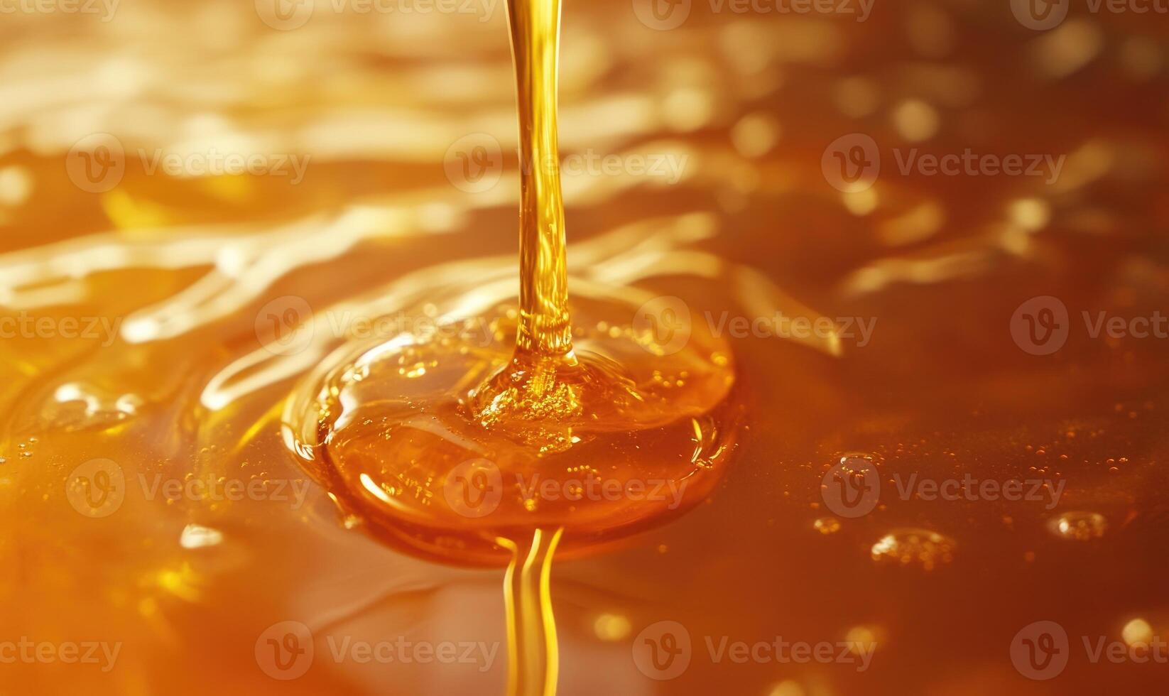 A stream of honey is pouring into a cup photo