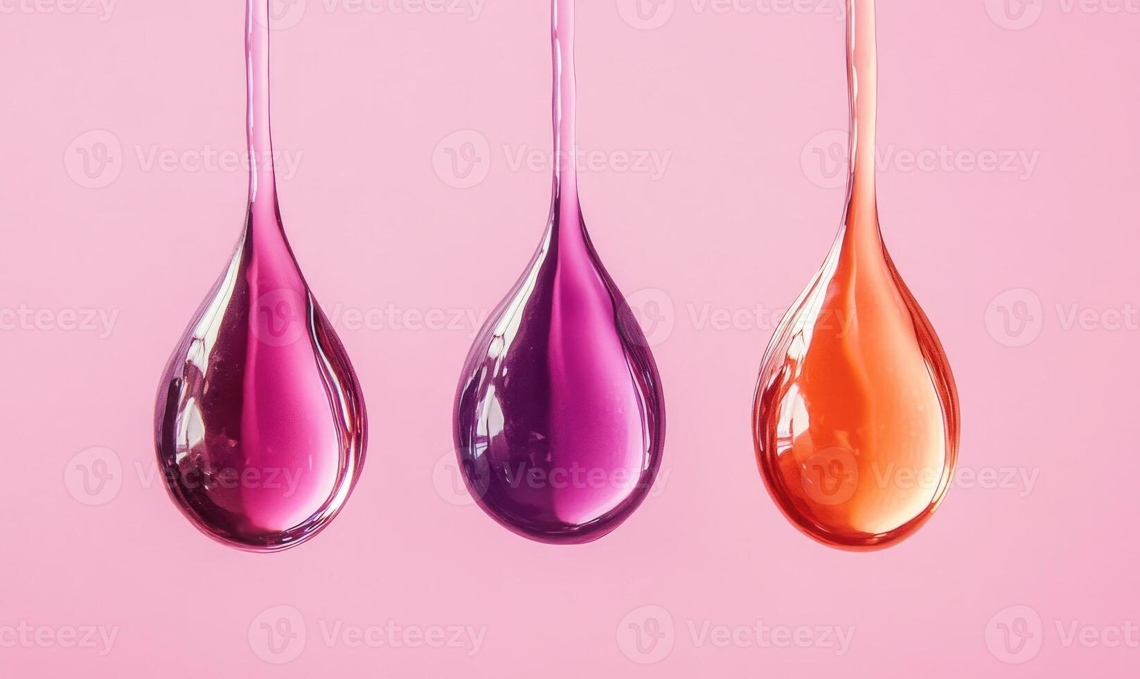 Three drops of liquid with different colors are hanging from a surface photo