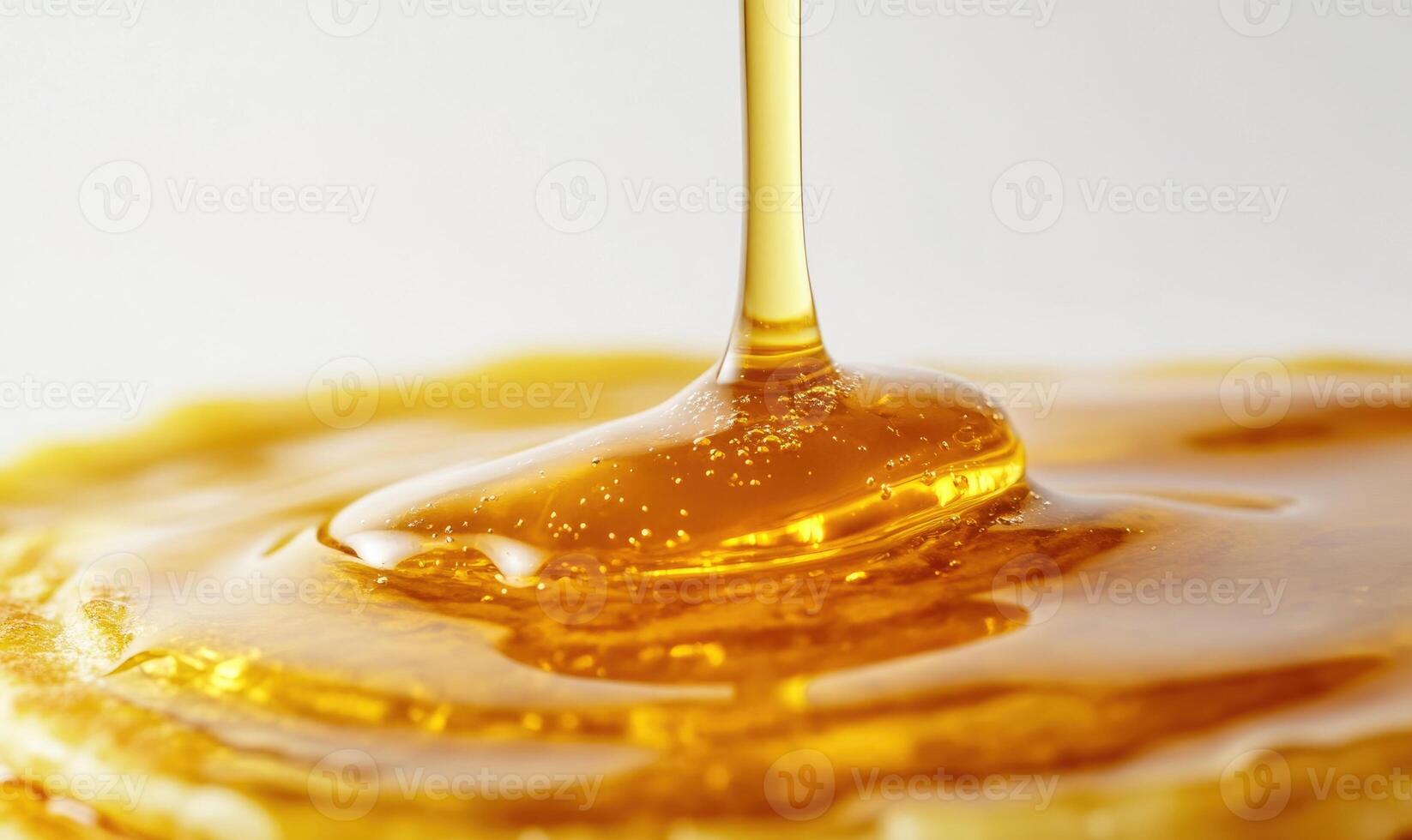 A spoonful of honey drips from a jar onto a stack of pancakes photo