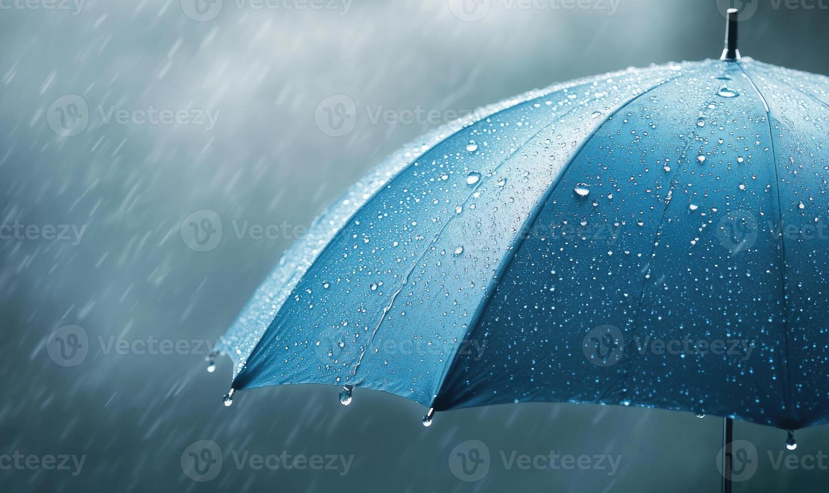 A blue umbrella is open in the rain photo