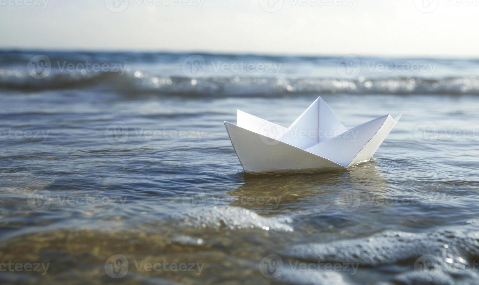 A white paper boat is floating in the ocean closeup view photo