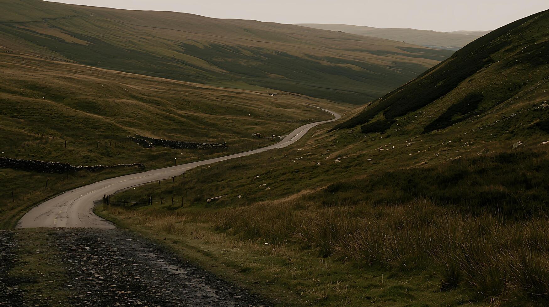 Winding Road Through Rolling Green Hills and Mountains. A scenic view of a countryside road curving through a serene landscape. photo