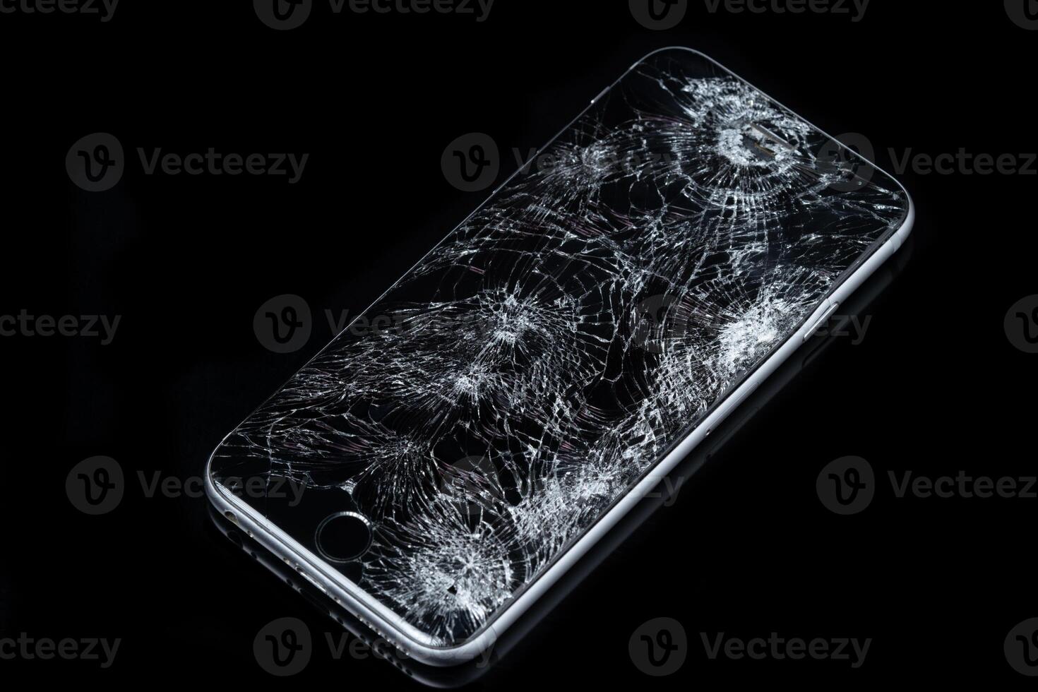 Smartphone with broken screen on dark background. photo