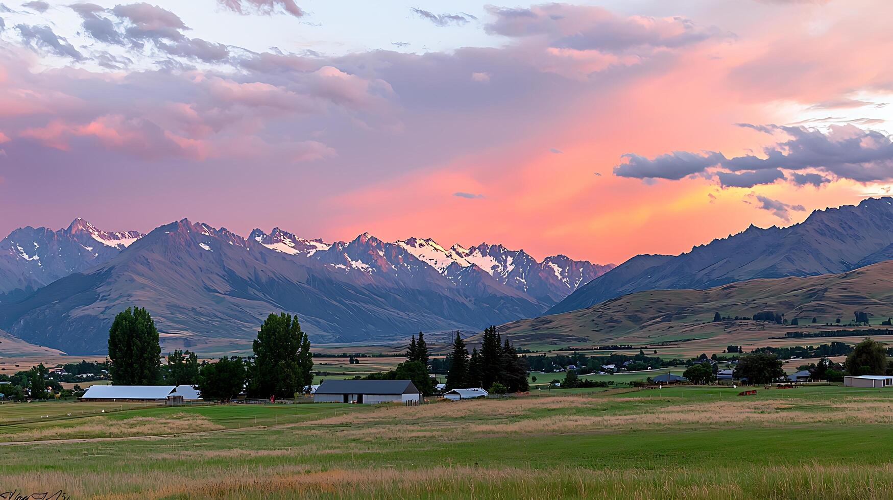 Serene Sunset over Snow-Capped Mountains and Rural Landscape. A picturesque view of a peaceful valley at sunset. photo