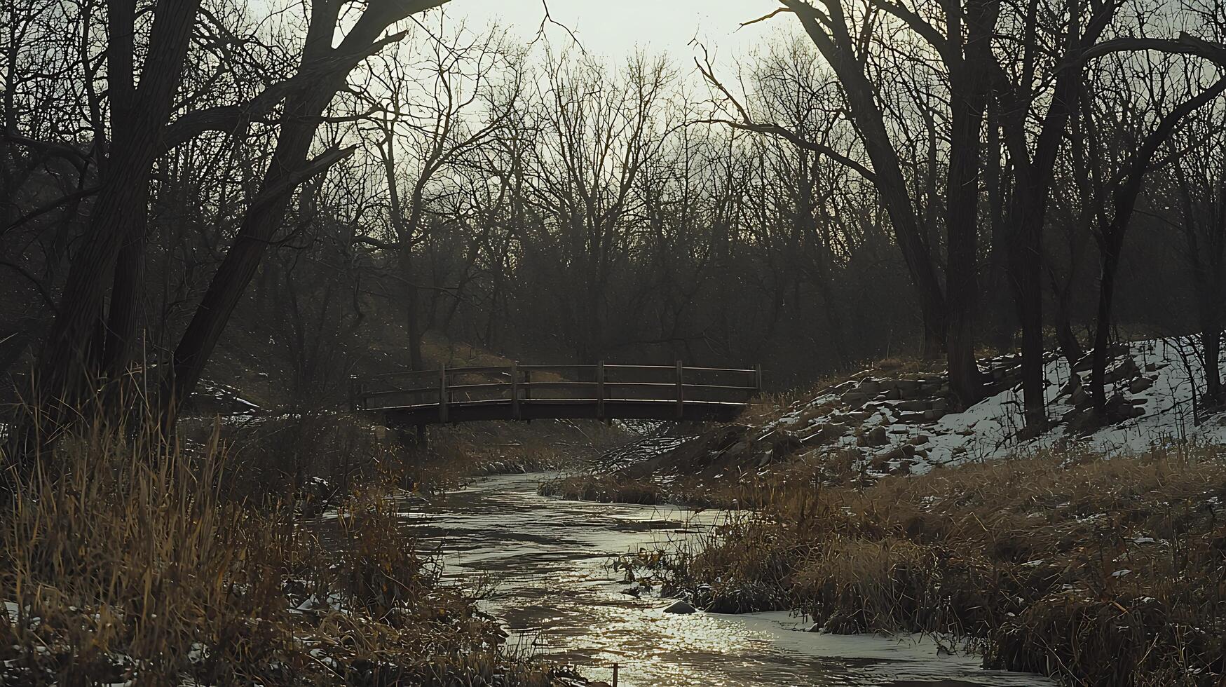 Serene Winter Creek Scene with Wooden Footbridge. A tranquil landscape photograph of a small creek flowing under a rustic bridge, surrounded by bare trees and winter's touch. photo
