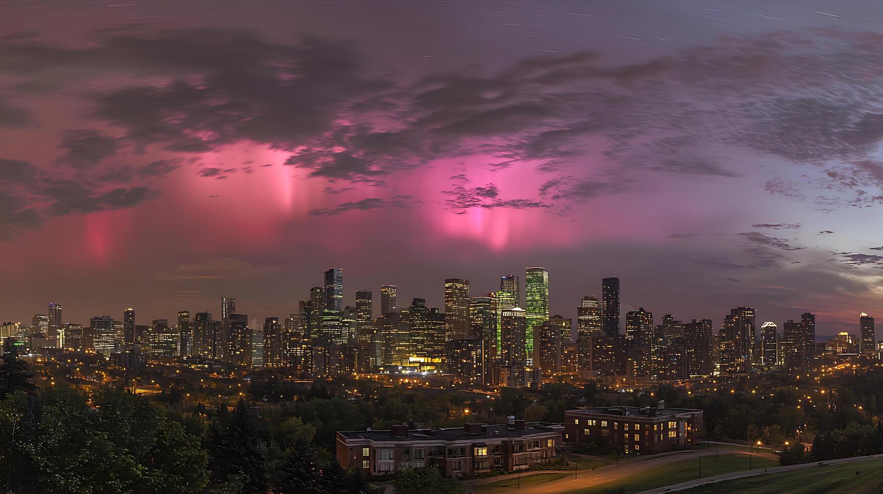 Pink Aurora Borealis Display Over Illuminated City Skyline at Night. photo