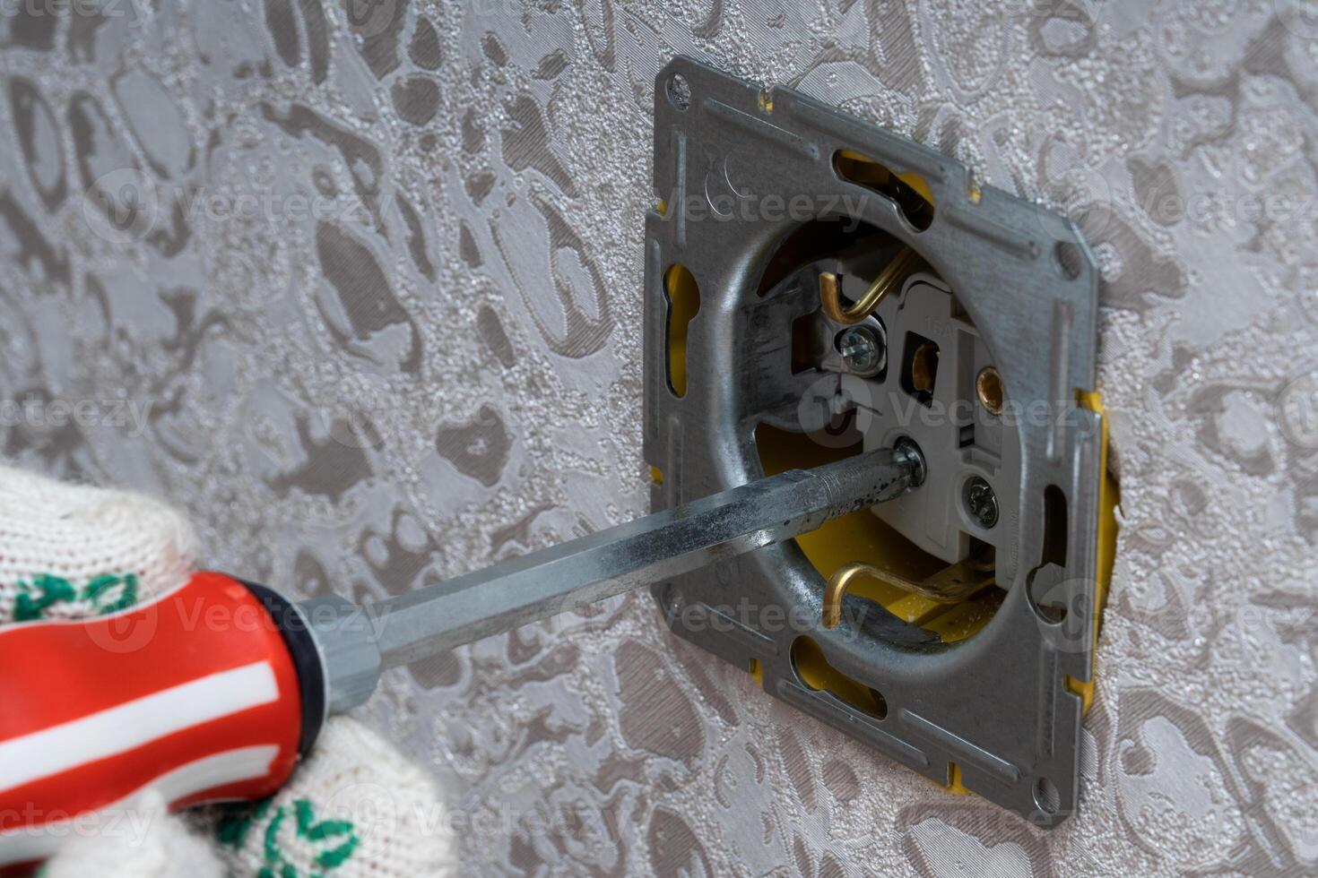 An electrician safely works with switches and sockets of a household electrical system photo