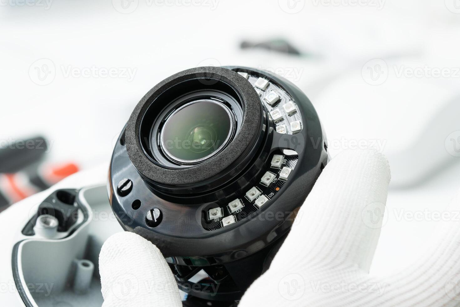 Close-up of the installation of a surveillance camera, a male hand in a white glove holds a surveillance camera. photo