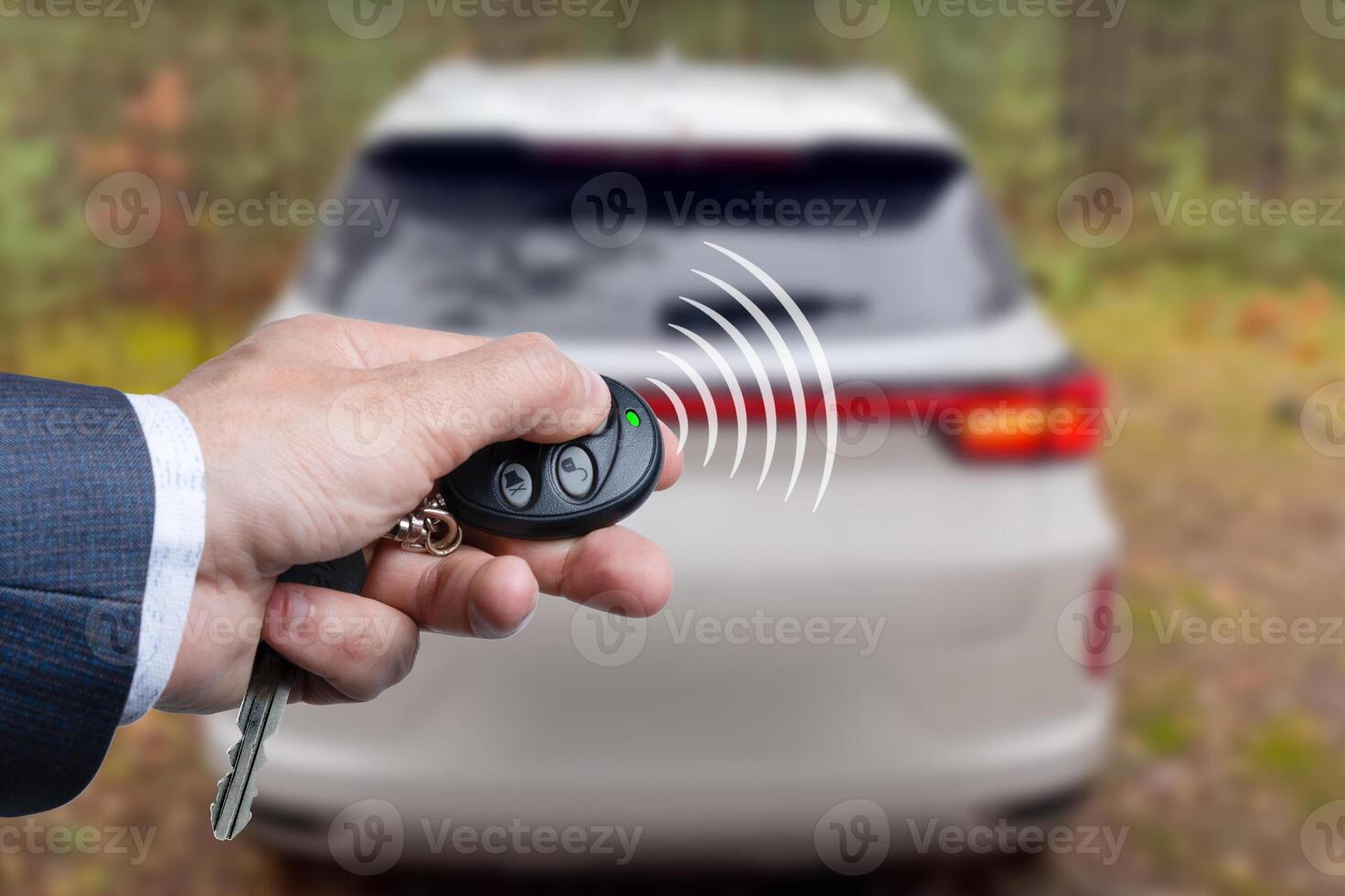 Men's hand presses on the remote control car alarm systems . photo