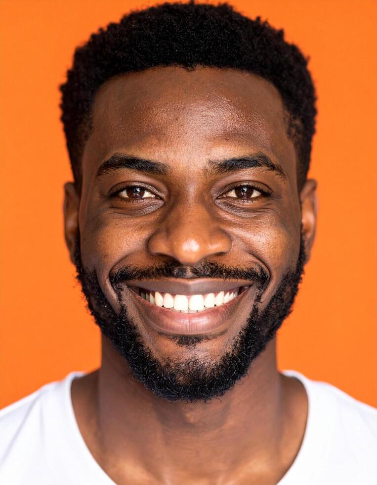 Happy African American man smiling brightly against a vibrant orange background a joyful portrait showcasing positive emotions and healthy teeth photo